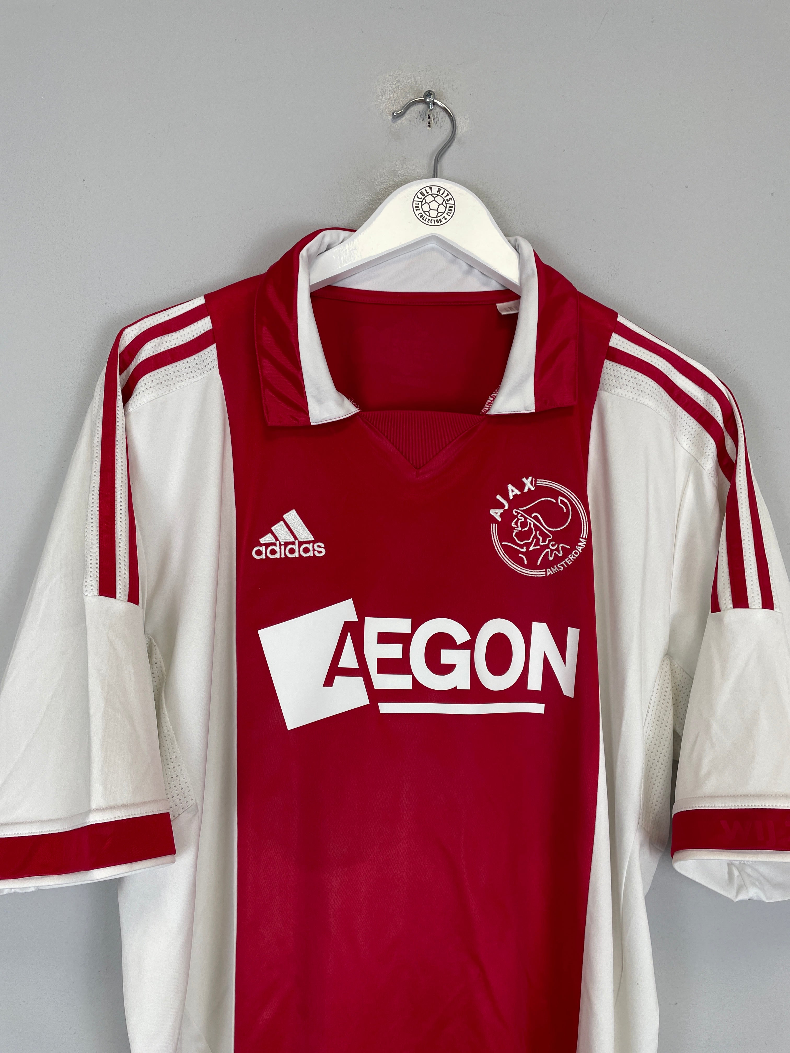 2011/12 Ajax home shirt by Adidas, size large, in excellent condition, featuring red and white design with Aegon logo.